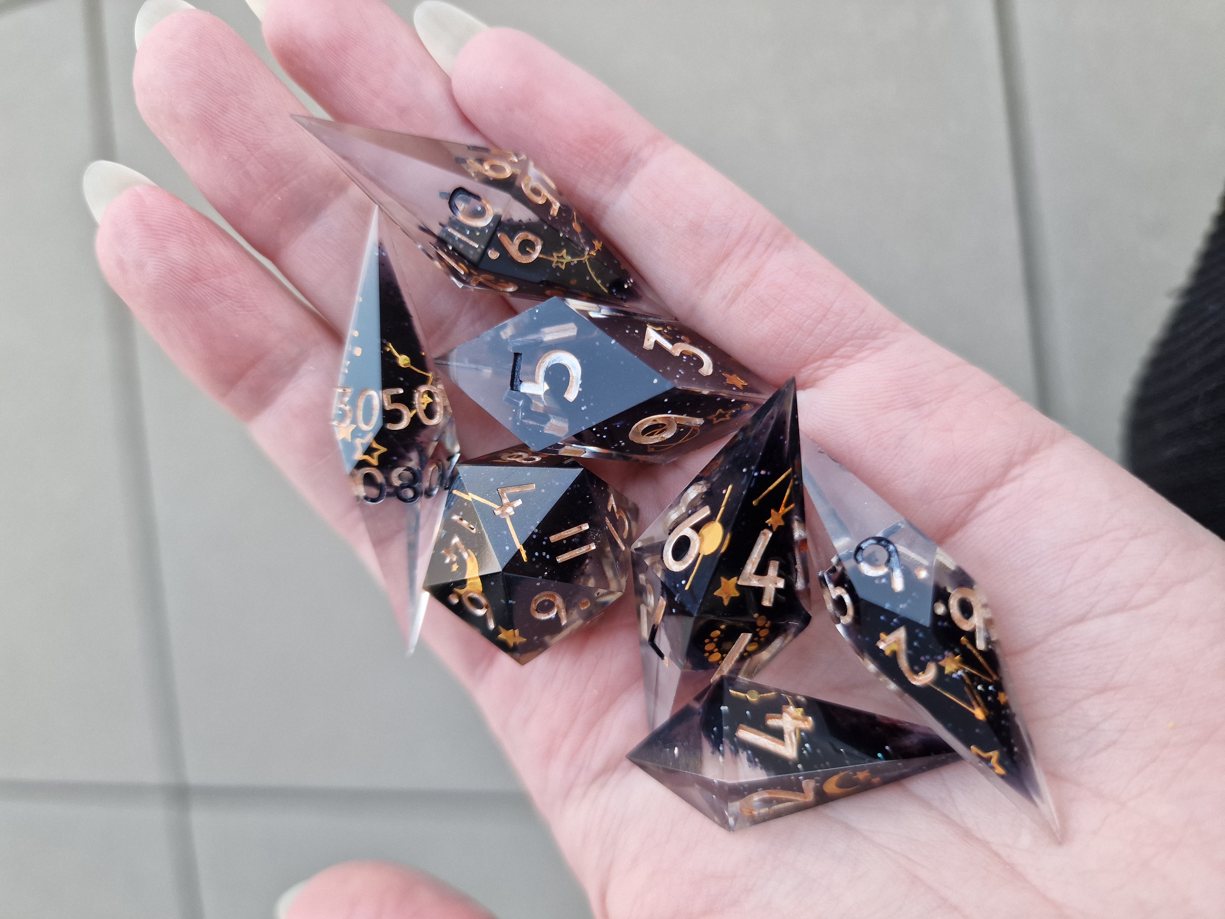 Golden stars and constellations float through clear and midnight-dark shards, finished with metallic numbers.
