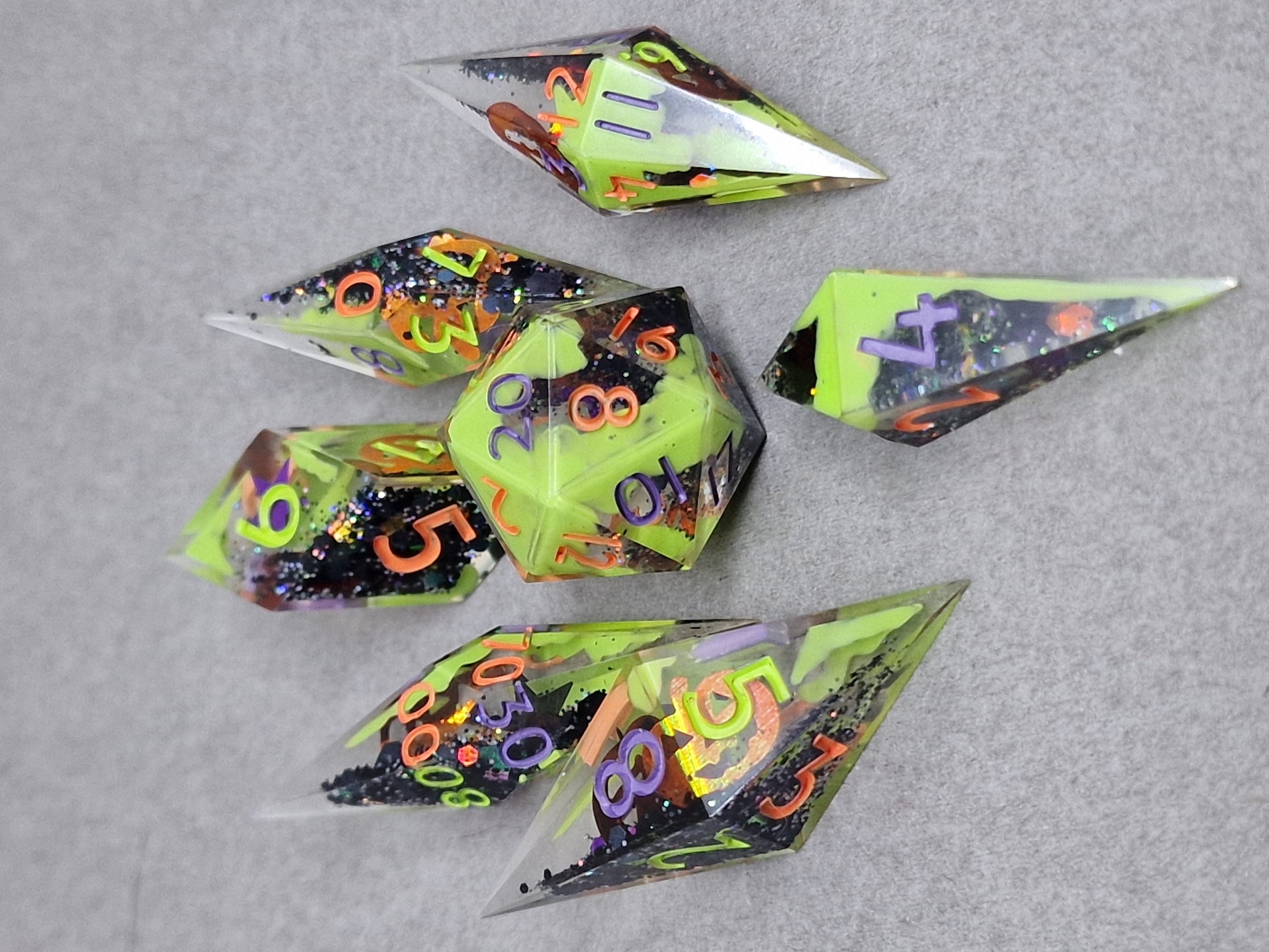 Lime-green ghostly shapes mingle with dark glitter and playful orange, purple, and green numbers.