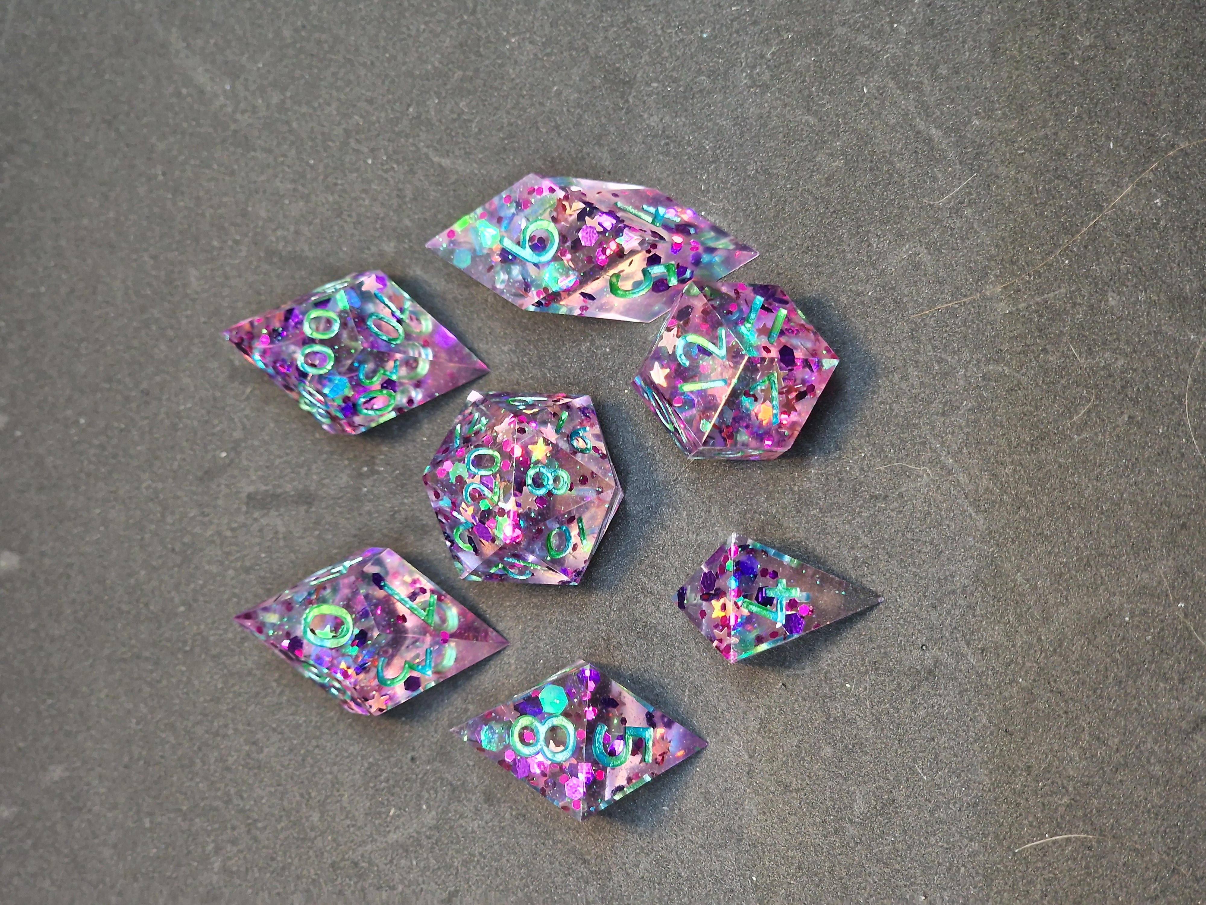 Clear pink dice sparkle with colourful stars and confetti beneath shifting turquoise numbers.