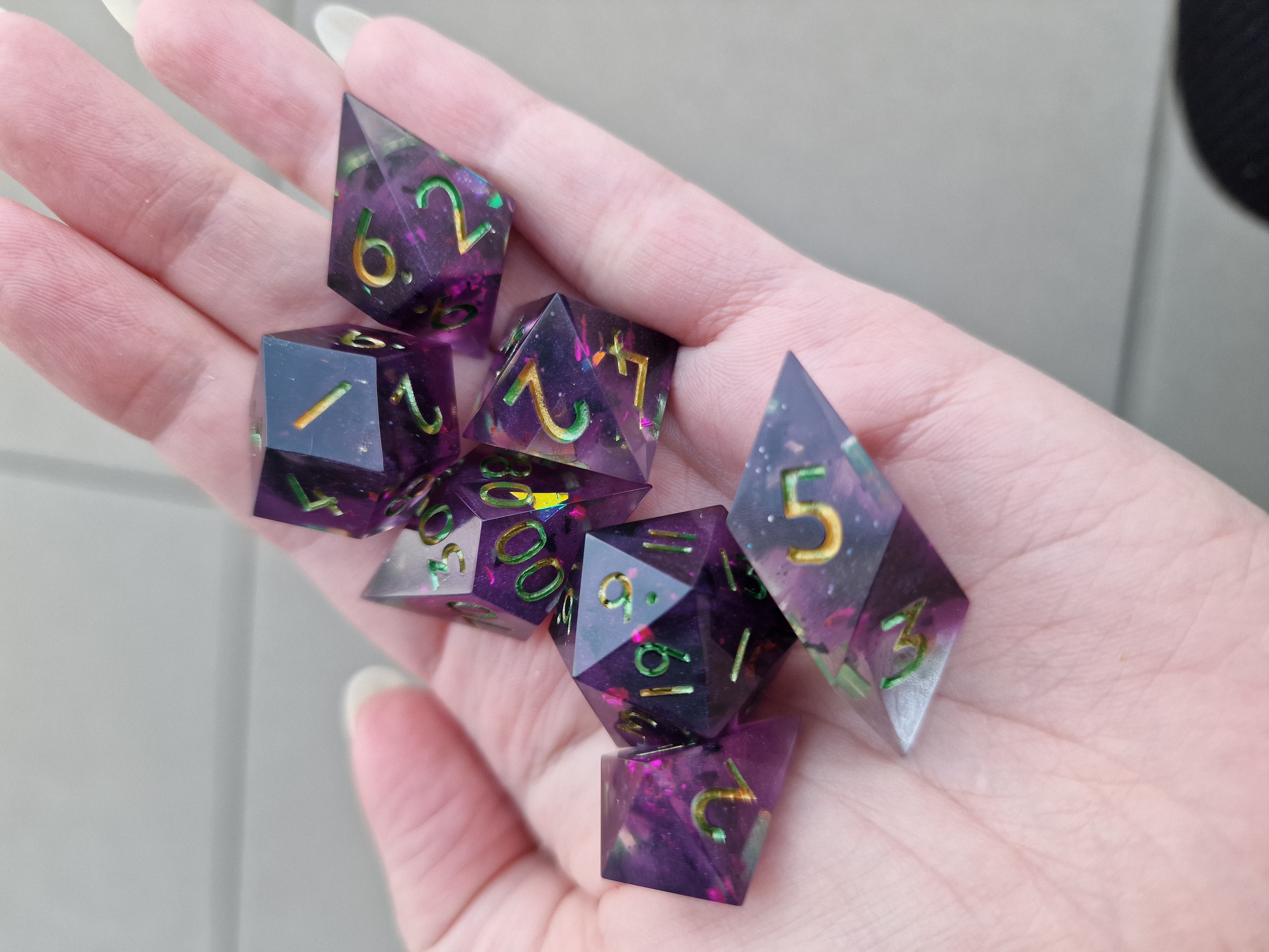 Deep violet resin holds flashes of iridescent colour, with numbers that shift from green to gold.
