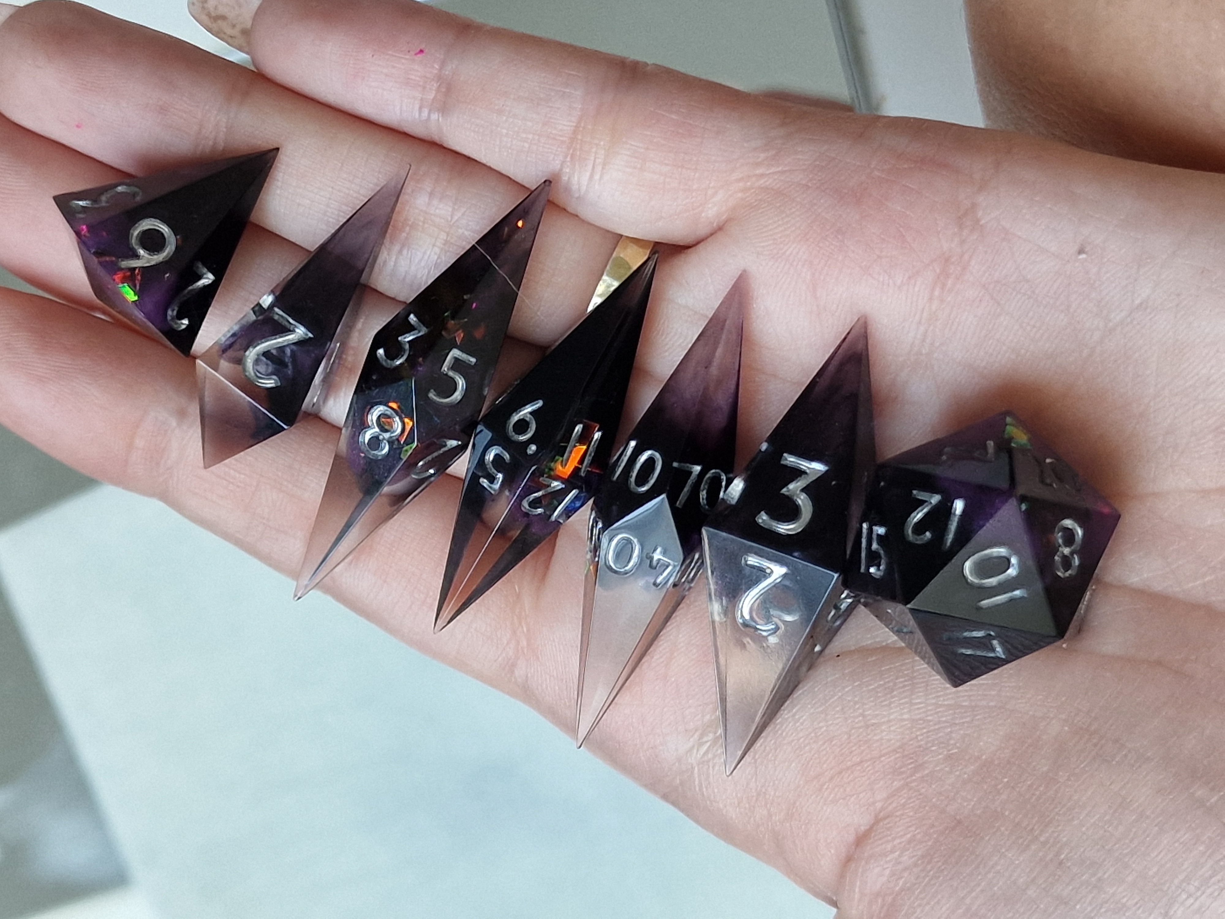 Smoky violet shards with silver numbers and iridescent sparks, like fragments of the night.